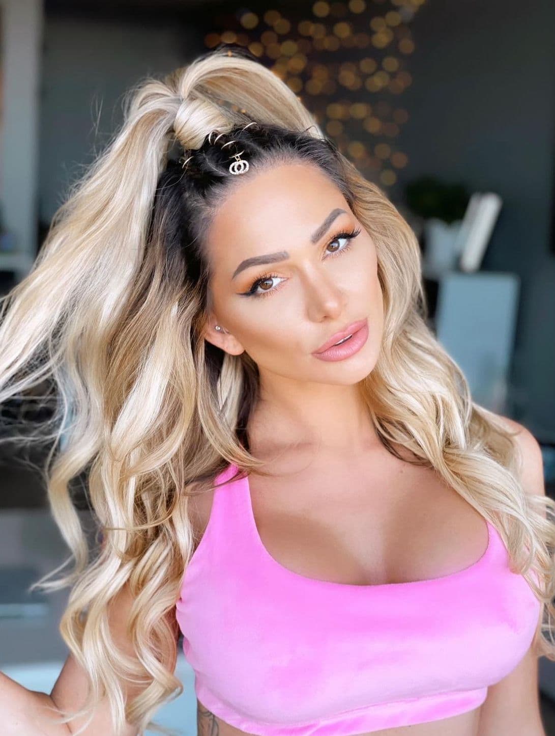 Blonde woman with braids, heat-styled ponytail, and crown hair accessories.