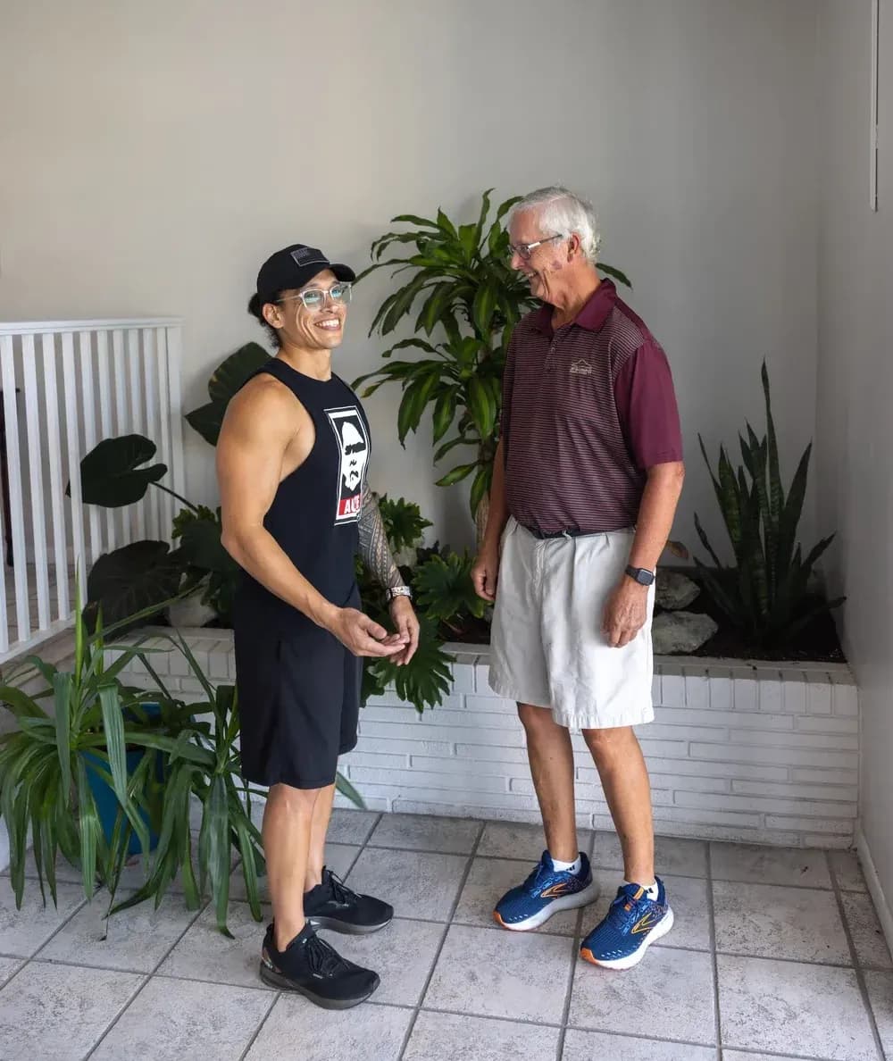 Man welcomes wellness provider for on-site assisted stretching sessions.