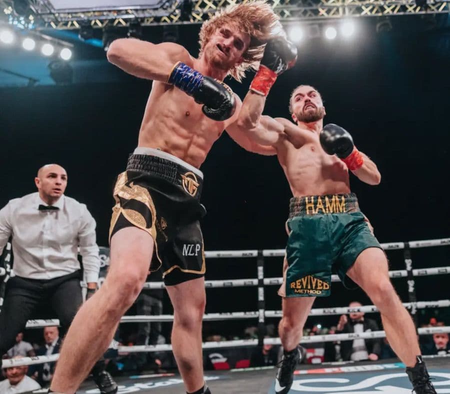 Professional boxer Tristan Hamm lands a right-hand punch on his opponent during a match as the referee watches.
