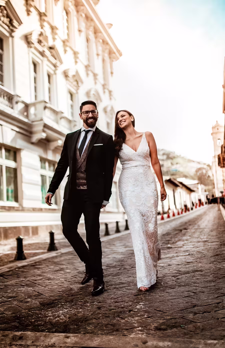 Newlyweds walking down a cobblestone street