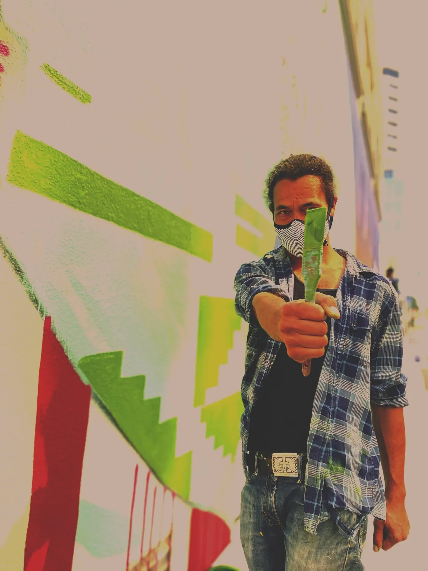 Sean Levon Nash standing in front of one of his murals