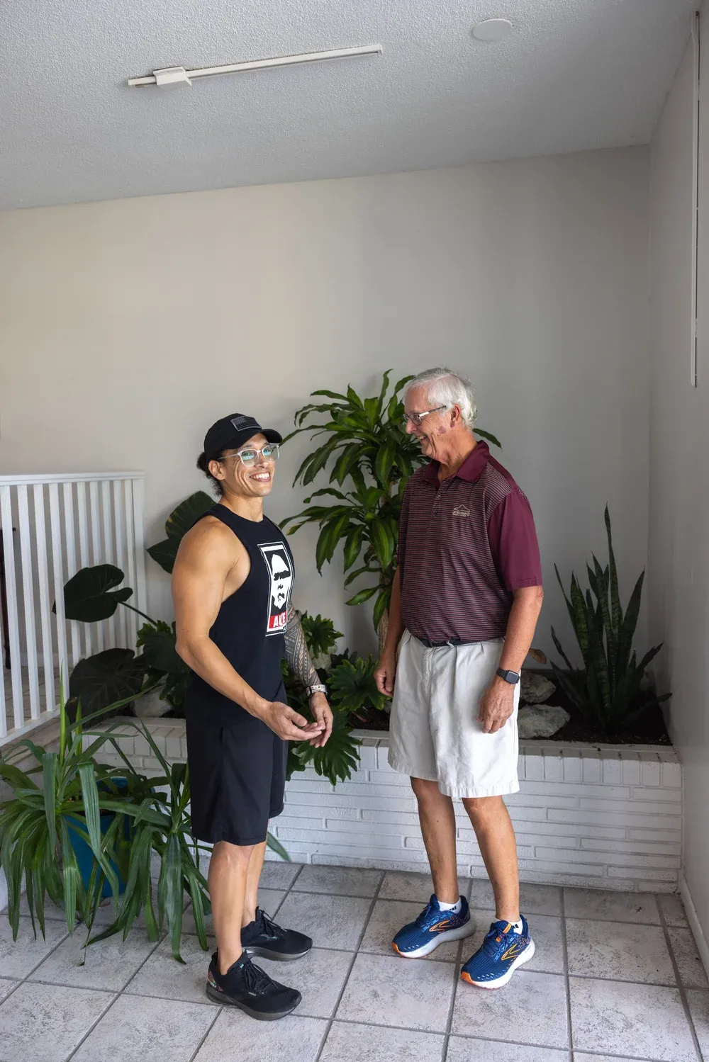 Man welcomes wellness provider for on-site assisted stretching sessions.