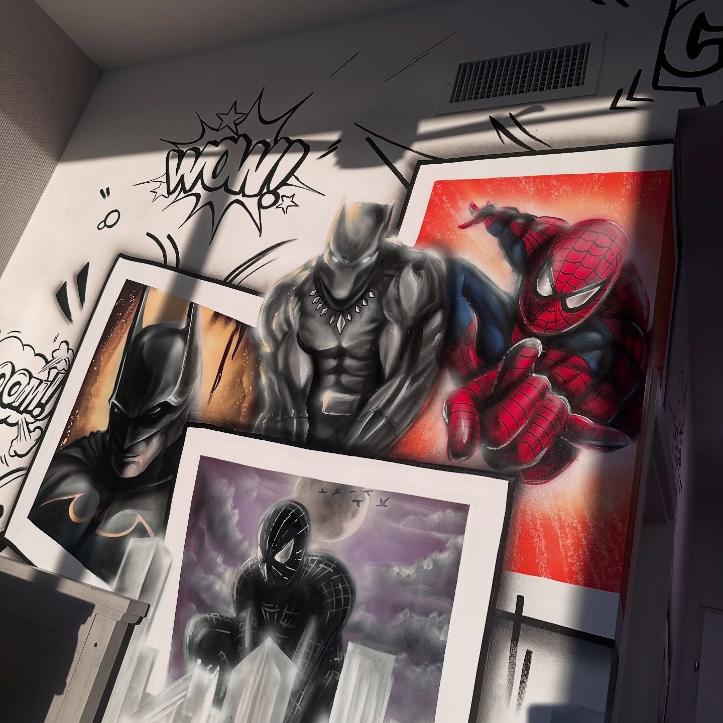 A custom superhero wall mural featuring detailed portraits of Spider-Man, Black Panther, and Batman in a comic book style.