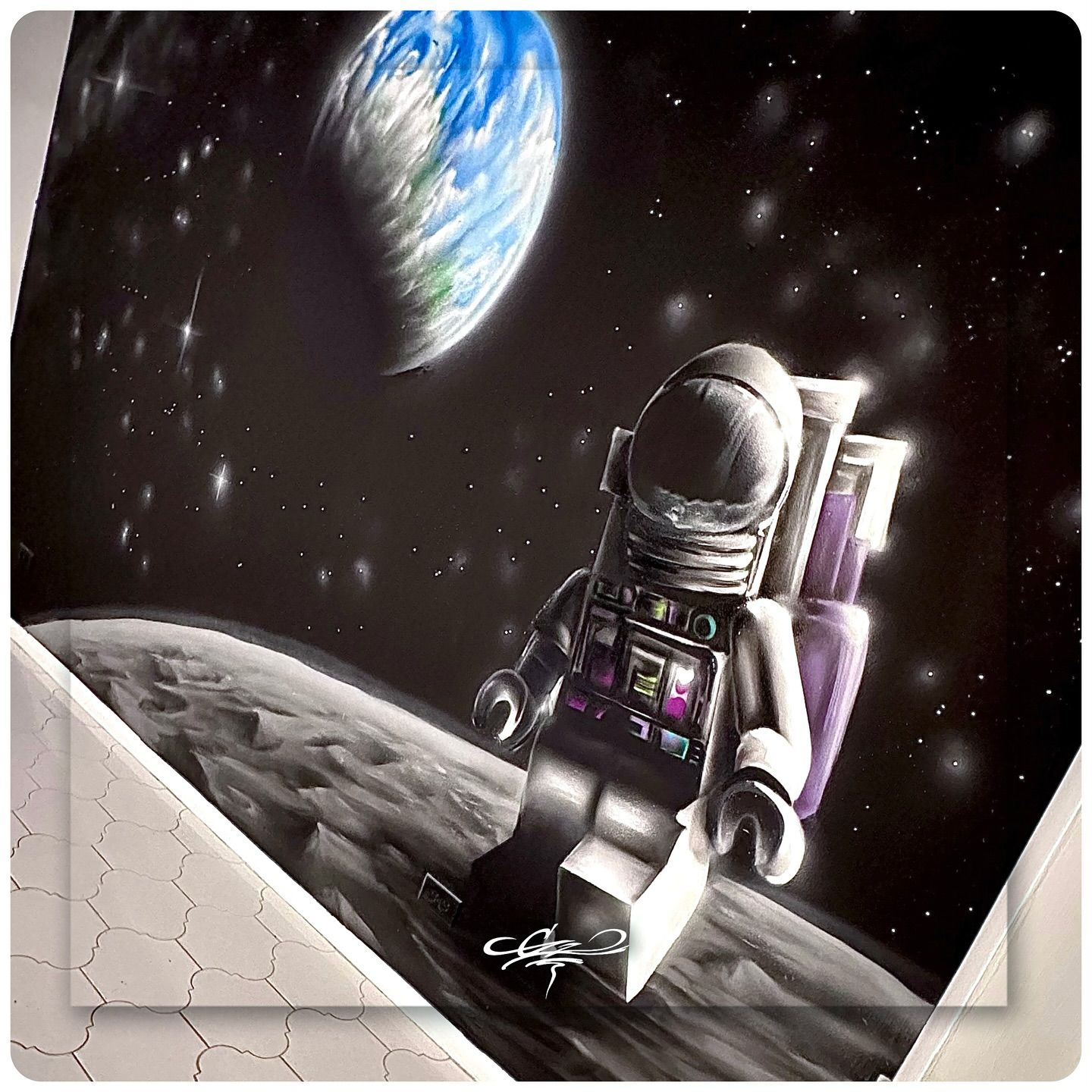 A spray paint mural of a LEGO astronaut standing on the moon, with Earth visible in the starry background.